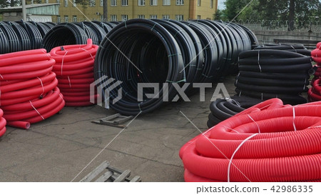 Warehouse of finished plastic pipes industrial outdoors storage site. Manufacture of plastic water 42986335
