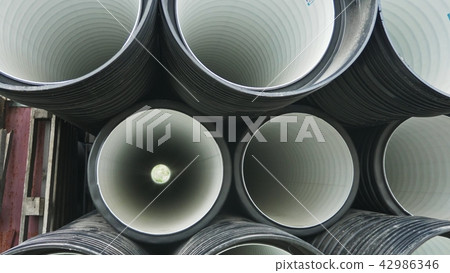 Warehouse of finished plastic pipes industrial outdoors storage site. Manufacture of plastic water Warehouse of finished plastic pipes industrial outdoors storage site. Manufacture of plastic water 42986346
