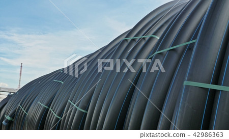 Warehouse of finished plastic pipes industrial outdoors storage site. Manufacture of plastic water 42986363