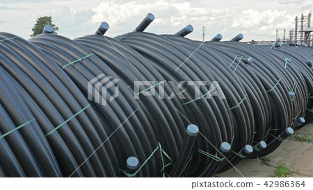 Warehouse of finished plastic pipes industrial outdoors storage site. Manufacture of plastic water Warehouse of finished plastic pipes industrial outdoors storage site. Manufacture of plastic water 42986364