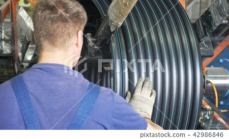 Roll threading coil pipe. Manufacture of plastic water pipes factory. Process of making plastic Roll threading coil pipe. Manufacture of plastic water pipes factory. Process of making plastic 42986846