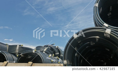 Warehouse of finished plastic pipes industrial outdoors storage site. Manufacture of plastic water Warehouse of finished plastic pipes industrial outdoors storage site. Manufacture of plastic water 42987185
