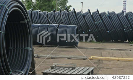 Warehouse of finished plastic pipes industrial outdoors storage site. Manufacture of plastic water Warehouse of finished plastic pipes industrial outdoors storage site. Manufacture of plastic water 42987232