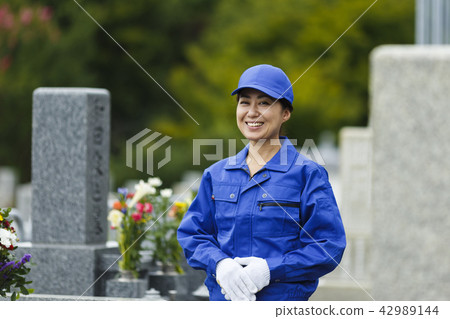 A woman in work clothes to clean the grave 42989144