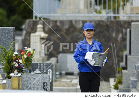 A woman in work clothes to clean the grave A woman in work clothes to clean the grave 42989149