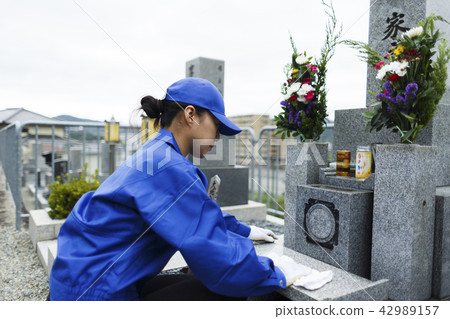 A woman in work clothes to clean the grave A woman in work clothes to clean the grave 42989157
