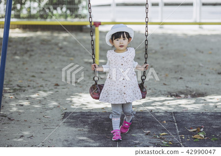 A girl playing with a swing 42990047