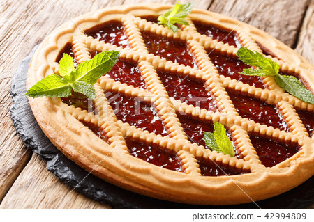 Italian cherry crostata pie decorated with mint Italian cherry crostata pie decorated with mint 42994809
