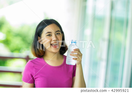 asian girl holding a bottle of cold water asian girl holding a bottle of cold water 42995921