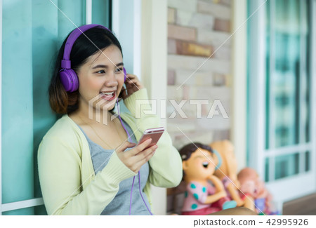 Young asian girl enjoy listening to music Young asian girl enjoy listening to music 42995926