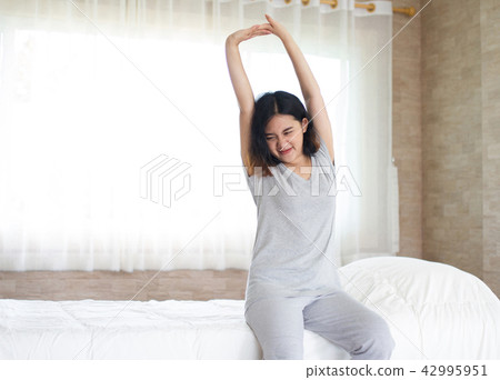 Asian girl stretching in bed Asian girl stretching in bed 42995951