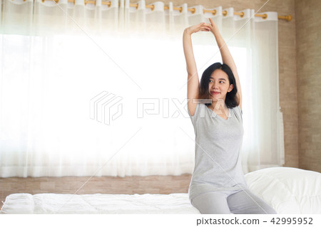 Asain girl stretching in bed Asain girl stretching in bed 42995952