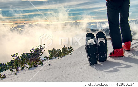Tall sportsman in warm clothes in snowshoes 42999134