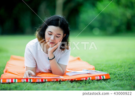 Young asian woman lying prone on a mat with tablet 43000922