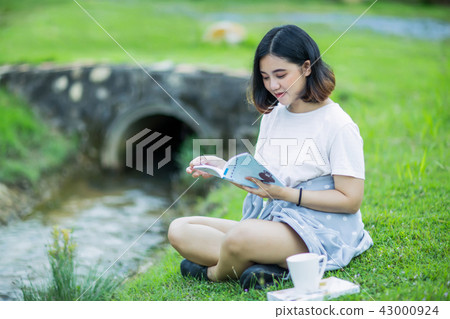 Asian girl reading a book in the garden Asian girl reading a book in the garden 43000924