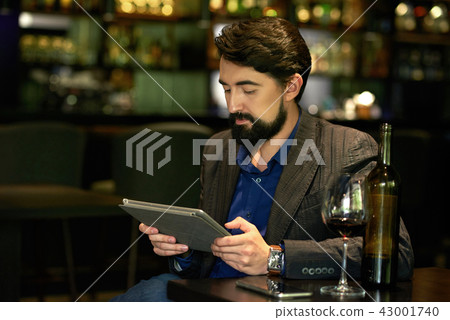 Man resting with bottle of wine in bar Man resting with bottle of wine in bar 43001740