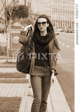 A black-haired girl in jeans outdoors A black-haired girl in jeans outdoors 43002717