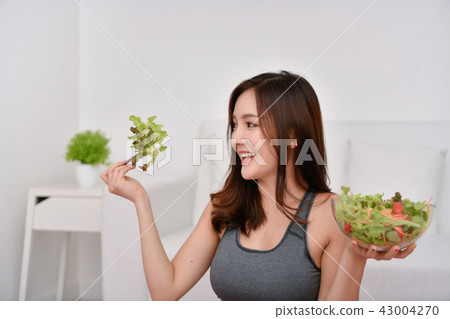 The concept of nutritional food. Beautiful girl takes care of he 43004270