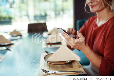 Smiling woman checking phone Smiling woman checking phone 43004523