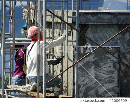 Construction workers plastering wall  43006709