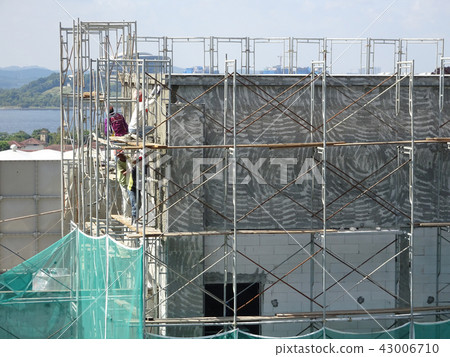 Construction workers plastering wall  43006710