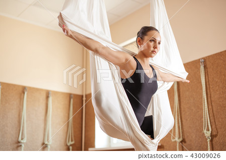 gifted female gymnast with stretched arms doing aerial exercise gifted female gymnast with stretched arms doing aerial exercise 43009026