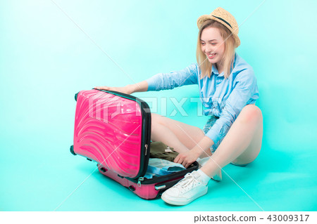 young woman opening her suitcase after holidays 43009317