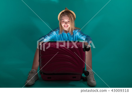 joyful tourist is opening her magic luggage 43009318