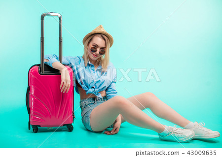 sexy stylish traveler sitting on the floor with pink baggage 43009635