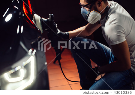 Car polish wax. worker hands holding a polisher Car polish wax. worker hands holding a polisher 43010386