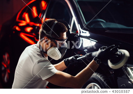 Car polish wax. worker hands holding a polisher Car polish wax. worker hands holding a polisher 43010387