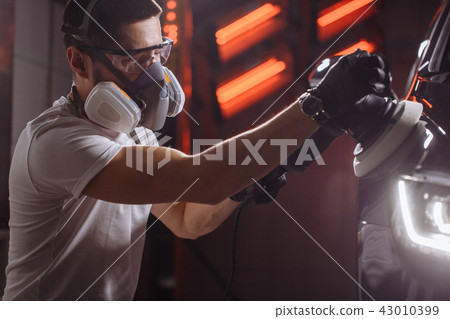 Car polish wax. worker hands holding a polisher Car polish wax. worker hands holding a polisher 43010399