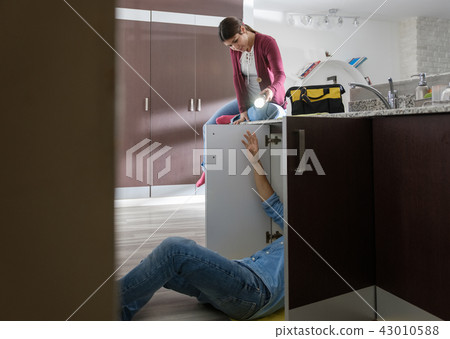 Handyman Husband and Wife Repairing Kitchen Sink 43010588