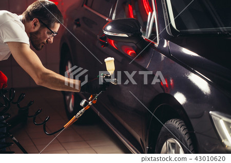 Car wash and coating business with ceramic coating.Spraying varnish to car. Car wash and coating business with ceramic coating.Spraying varnish to car. 43010620