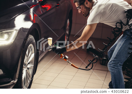 Car wash and coating business with ceramic coating.Spraying varnish to car. Car wash and coating business with ceramic coating.Spraying varnish to car. 43010622