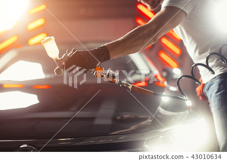 Car wash and coating business with ceramic coating.Spraying varnish to car. Car wash and coating business with ceramic coating.Spraying varnish to car. 43010634