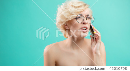 Angry attractive blond woman shouts while talking on the phone 43010798