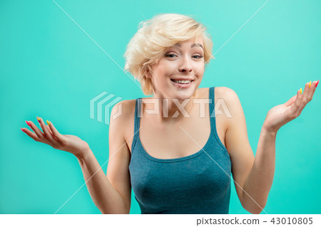 young puzzled woman shrugs shoulders. facial expression concept 43010805