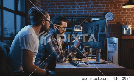 Men creating cartoon on computer Men creating cartoon on computer 43010955