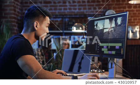 Ethnic man editing video on computer Ethnic man editing video on computer 43010957