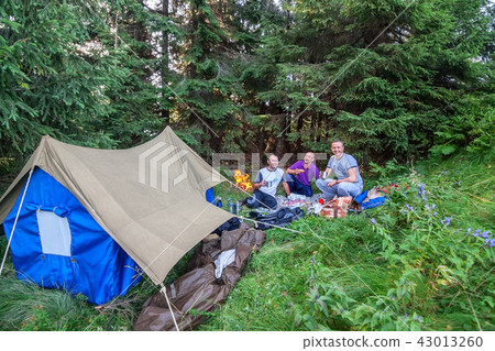 Tourists near the fire, rest in the Carpathian Mountains. Tourists near the fire, rest in the Carpathian Mountains. 43013260