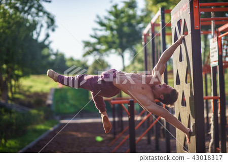 Muscular man making flag on the street. Street workout 43018317