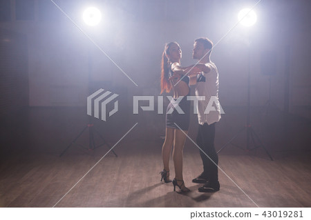 Young couple dancing social danse kizomba or bachata or semba or taraxia in dancing class background 43019281