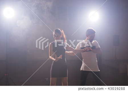 Young couple dancing social danse kizomba or bachata or semba or taraxia in dancing class background Young couple dancing social danse kizomba or bachata or semba or taraxia in dancing class background 43019288