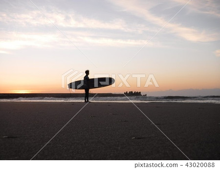 A surfer that is about to enter the sea from now on 43020088