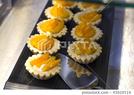 Tartlets with fresh peaches and arbicos on tray Tartlets with fresh peaches and arbicos on tray 43020519