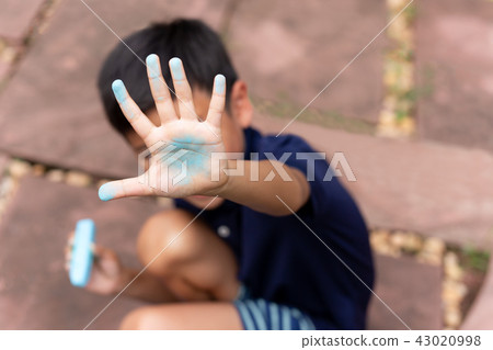Little boy with dirty hand of blue chalk Little boy with dirty hand of blue chalk 43020998