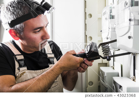 Electrician testing equipment in fuse switch box Electrician testing equipment in fuse switch box 43023368