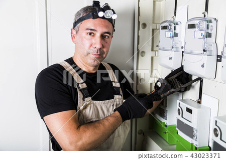 Electrician testing fuse box on head close-up 43023371