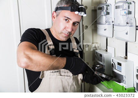 Electrician testing fuse box on head close-up Electrician testing fuse box on head close-up 43023372